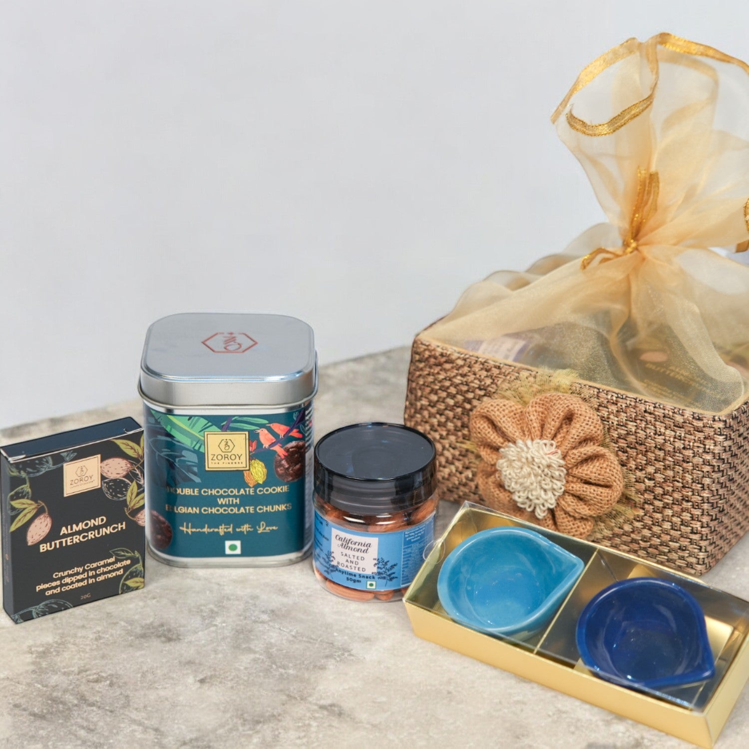 ZOROY Jute Essential Hamper – Stylish Resuable Jute Gift Basket containing Chocolates , 2 Ceramic Diyas, Handcrafted Cookies, Assorted Chocolates,  Californian Almonds – Ideal Gift Set for Special Occasions, Diwali Gifting