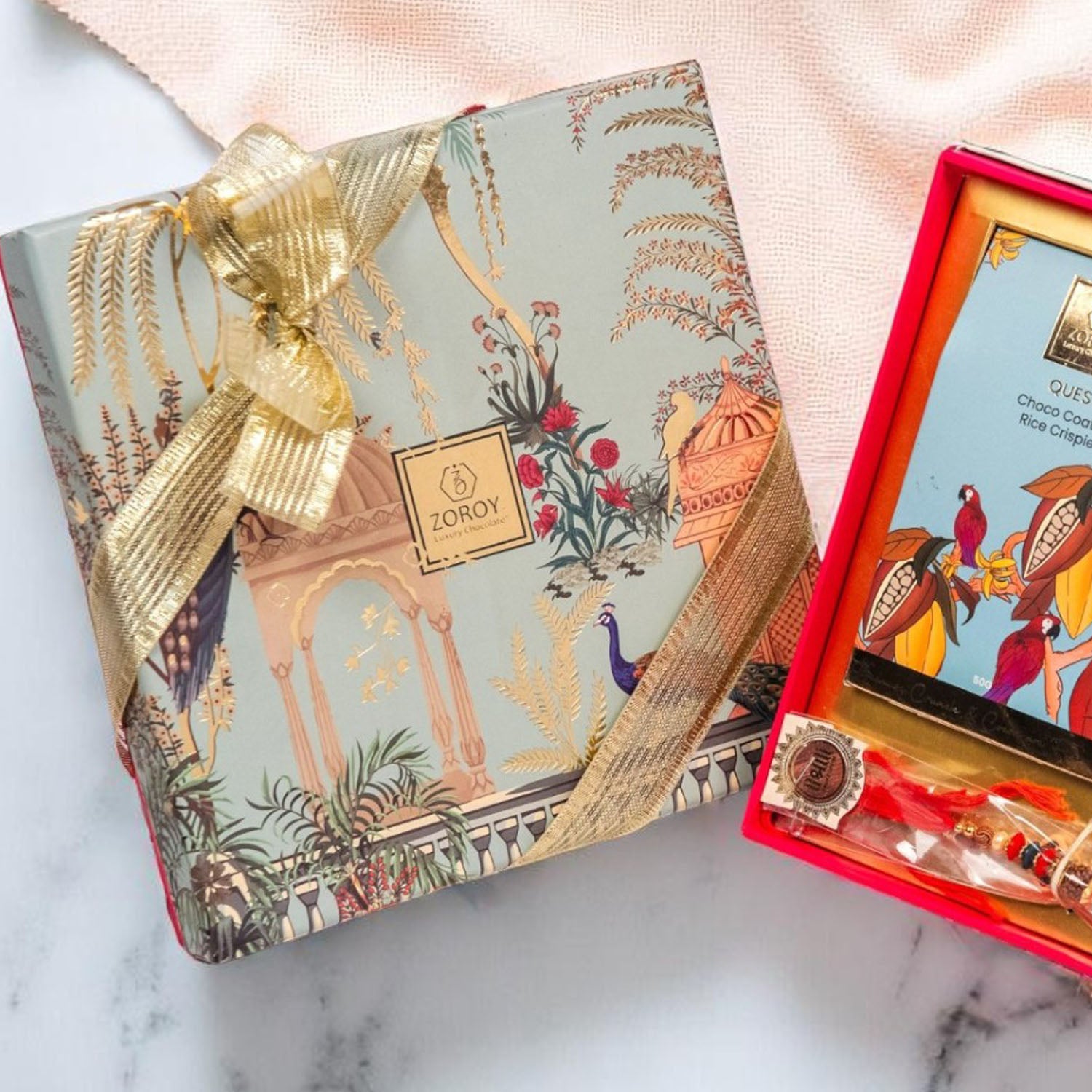 ZOROY Rakhi Gift Kit | Compact Raksha Bandhan Hamper with Quest Choco Rice Crisps, 2 Rakhis, Akshat Kumkum, Rakhi Card | Essentials-Only Rakhi Gift Box for Brother, Bhabhi, Kids & Family