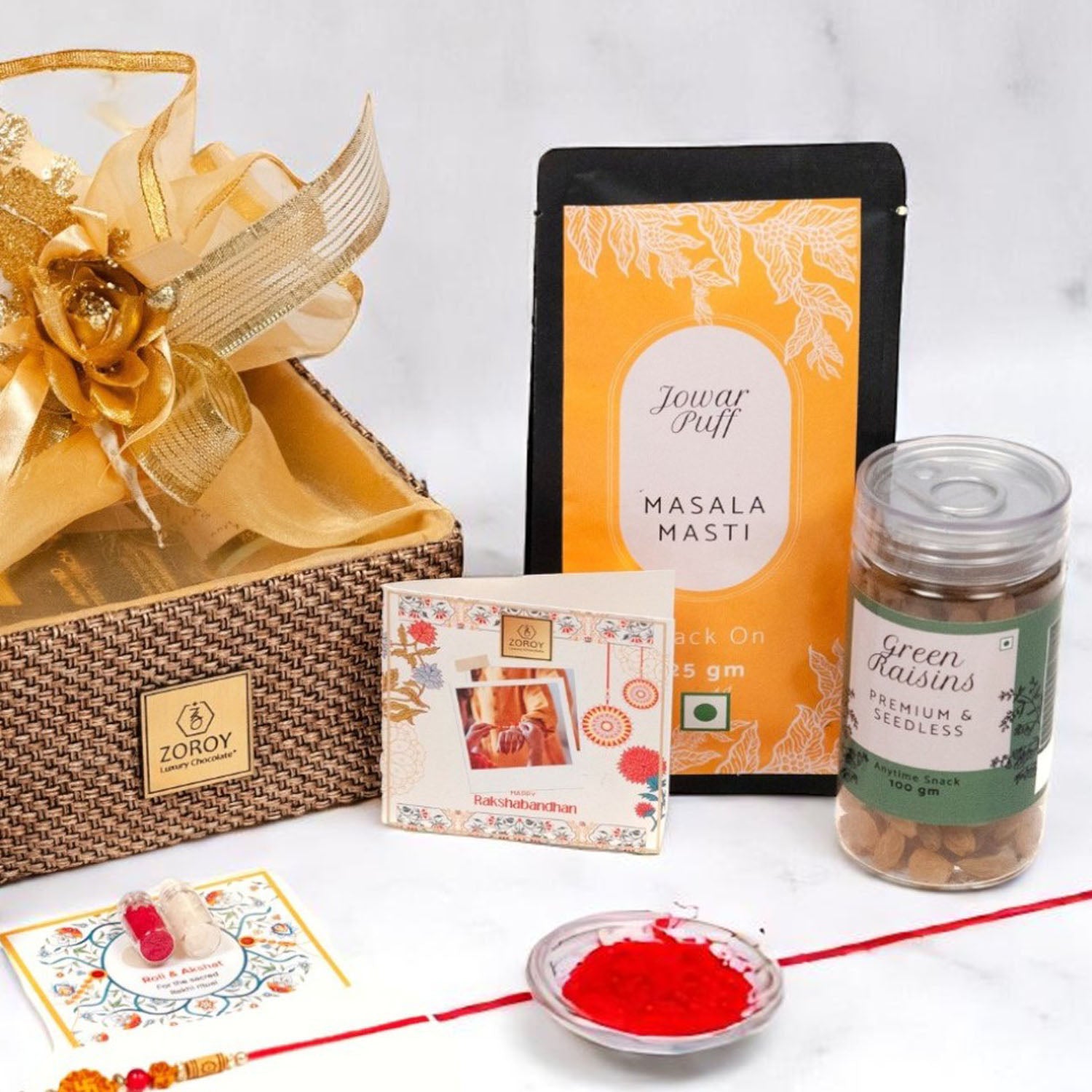 ZOROY Raksha Bandhan Organza  Gift Hamper with Rakhi, Akshat Kumkum, Rakhi Card, Chocolate Lava Cookie, Buttercrunch Snack, Raisins 100g  – Rakhi Gift for Brother, Bhai, Sibling