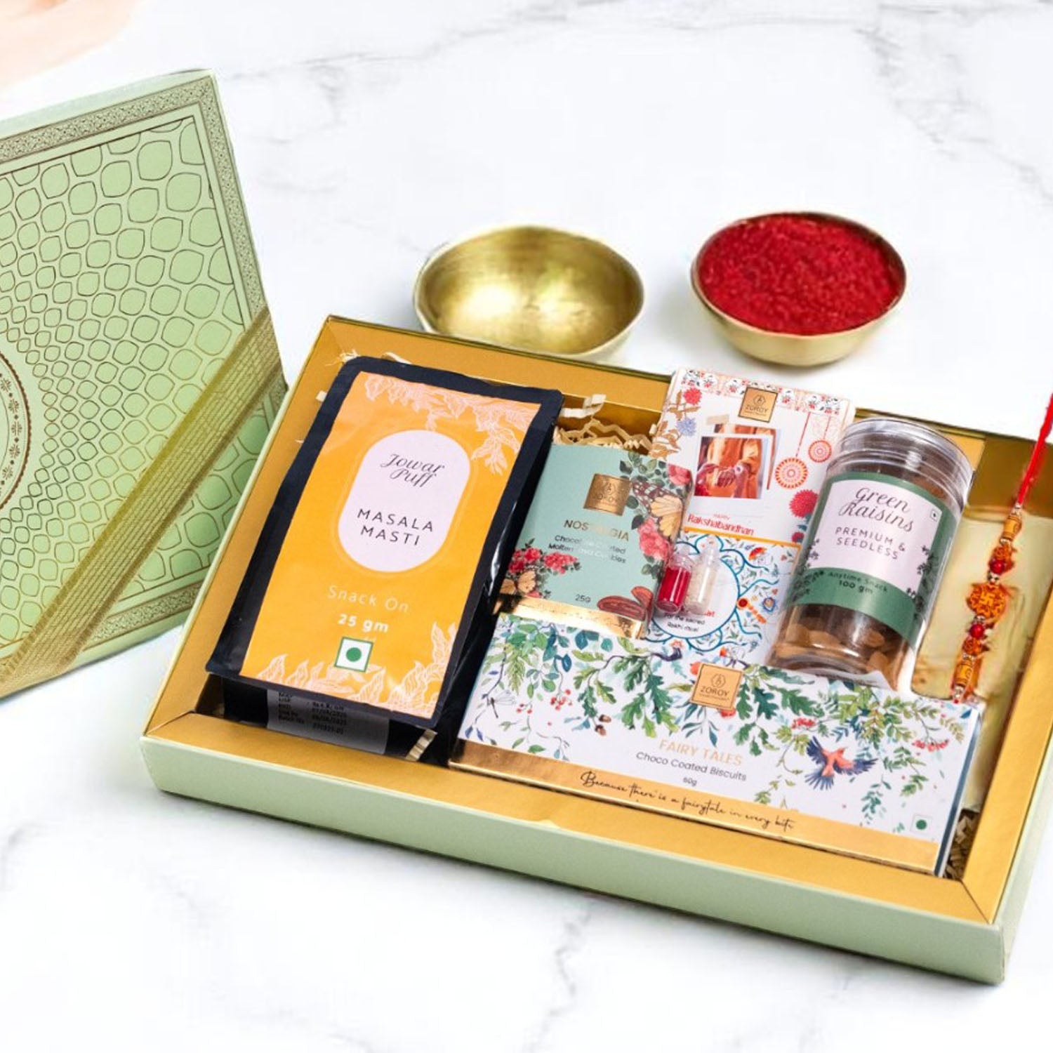 ZOROY Elegant Peacock Rakhi Gift Box | Snack Pack, Almond Buttercrunch, Chocolate-Dipped Fairy Tale Biscuits, Raisins 100g, Rakhi, Akshat Kumkum & Greeting Card | Raksha Bandhan Gift for Brother & Sister