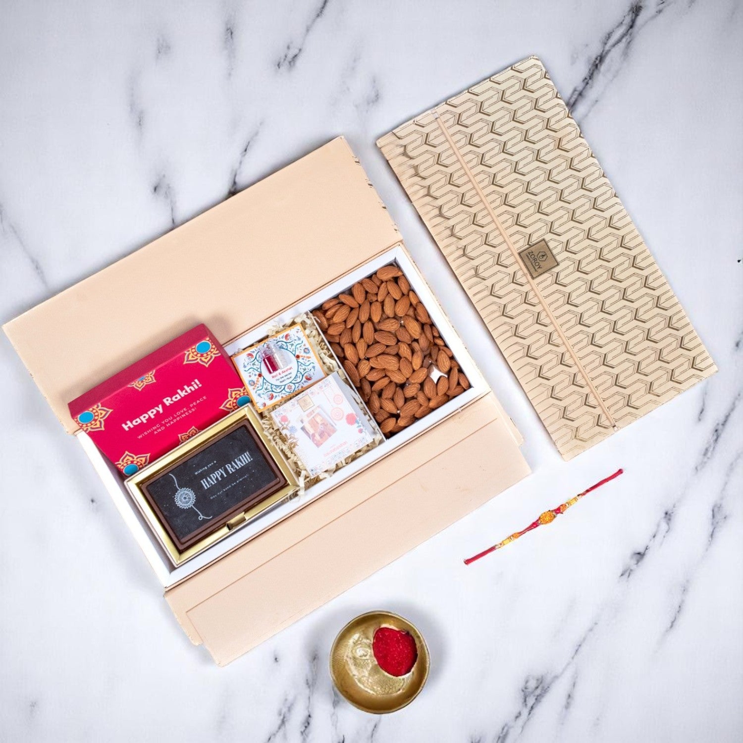 ZOROY Rakhi Wing Gift Hamper with Happy Rakhi Chocolate Box, Designer Rakhi, Almonds 100g, Akshat Kumkum, Rakhi Card | Rakhi Gift for Brother | Raksha Bandhan Celebration Essentials Box